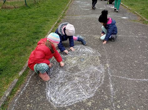 Ilustrácia dieťaťa kresliaceho kriedami na chodník