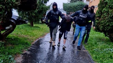 Policajti odvádzajú obvinených v putách