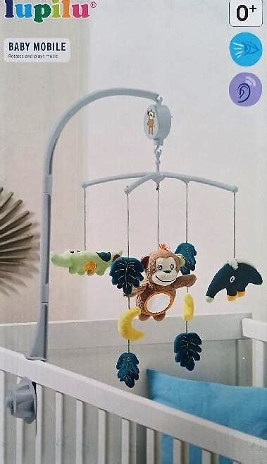 Hračky zavesené nad detskou postieľkou