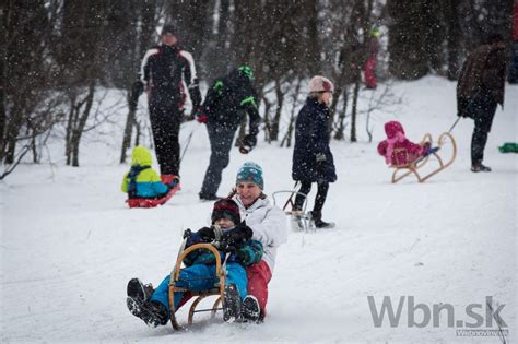Deti sa sánkujú na zasneženom kopci