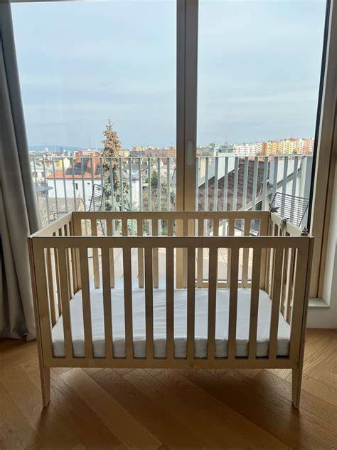 Obrázok bukovej detskej postieľky s nastaviteľnou výškou roštu a odnímateľnou bočnicou
