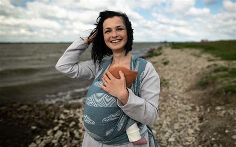 Matka dojčí dieťa v nosiči