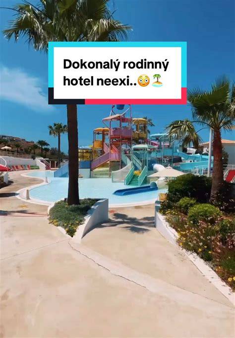 Obrázok zobrazuje rozsiahly rodinný rezort s piesočnatou plážou a palmami.