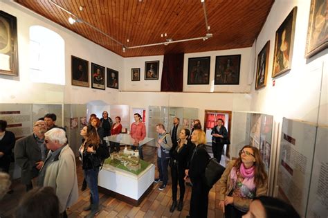 Návštevníci prehliadajú expozíciu s historickými lyžiami a bobmi
