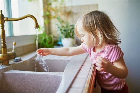 Dieťa s radosťou umýva riad v kuchyni